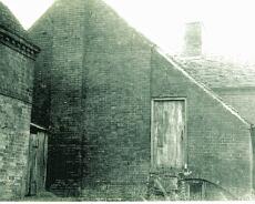 img20211208_0100 Rear of the Bell Inn. This shows the steps up to the door of the Chicken House below which is the arch of the 3/4 cellar used to store the ale